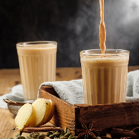 two faceted glass glasses wooden table with traditional indian drink masala chai